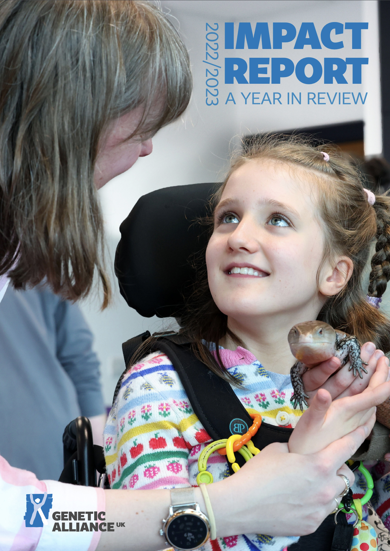 Genetic Alliance UK's Impact Report cover. A young girl smiles up to an older woman. The young girl sits in a wheelchair and holds a lizard. She wears a colours patterned top.