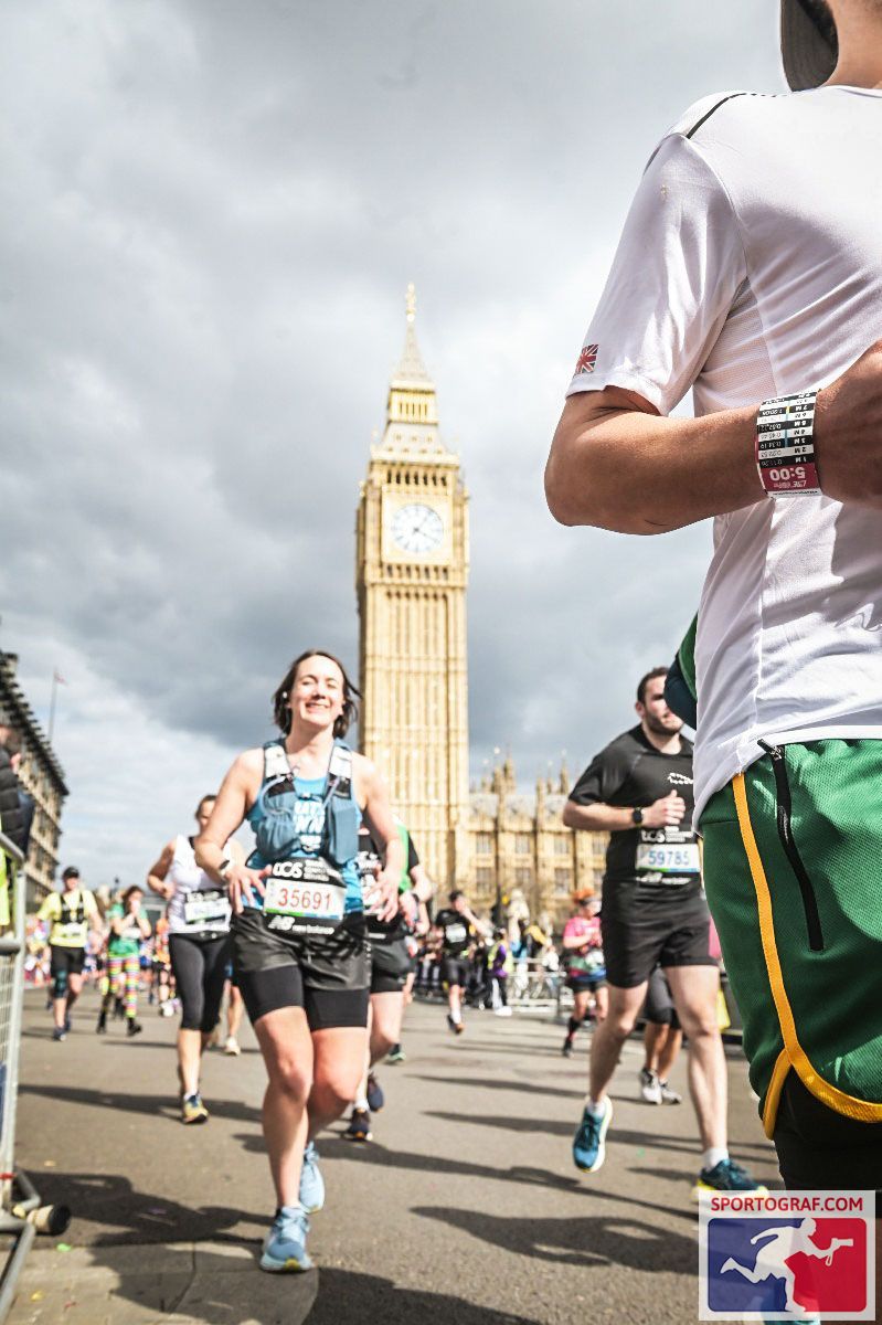 Sarah running amongst other in the London Marathon. She runs by Big Ben, a large clock tower at the UK Parliament.