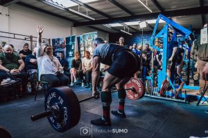 Keir powerlifting in front of an audience during a competition