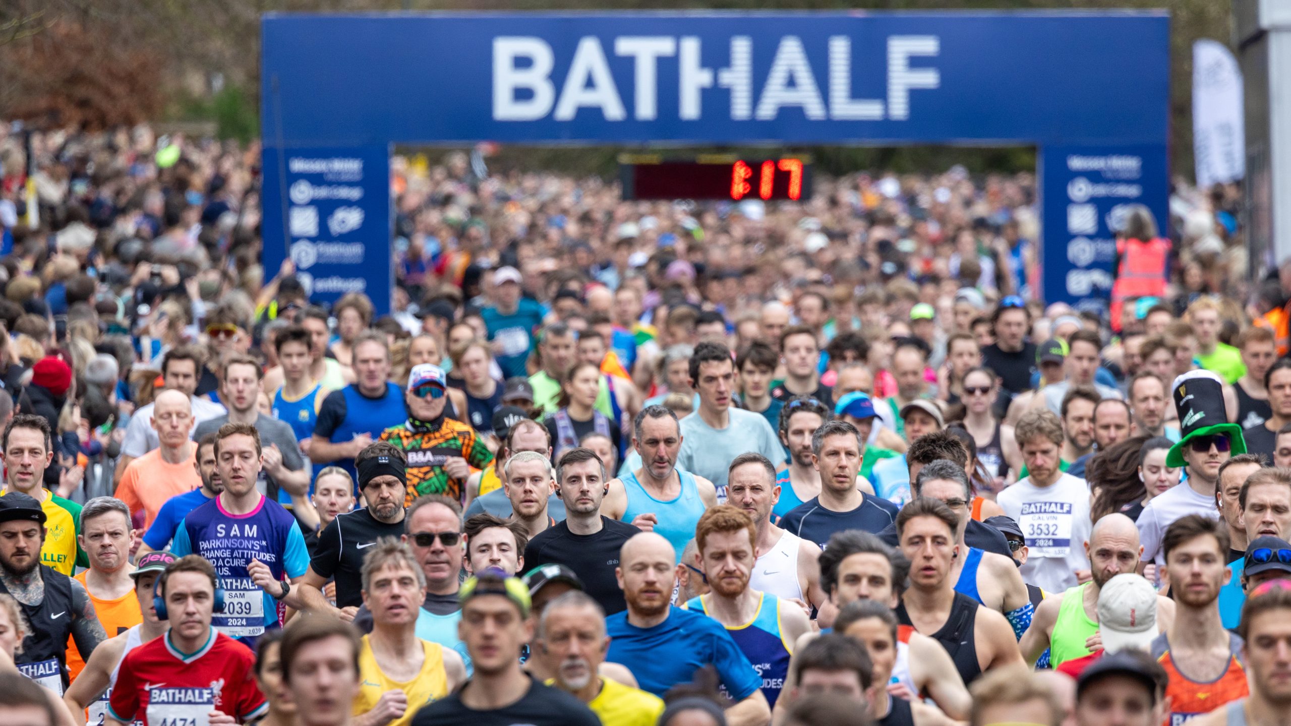 runners at the start line of the Bath Half Marathon with their banner above the runners