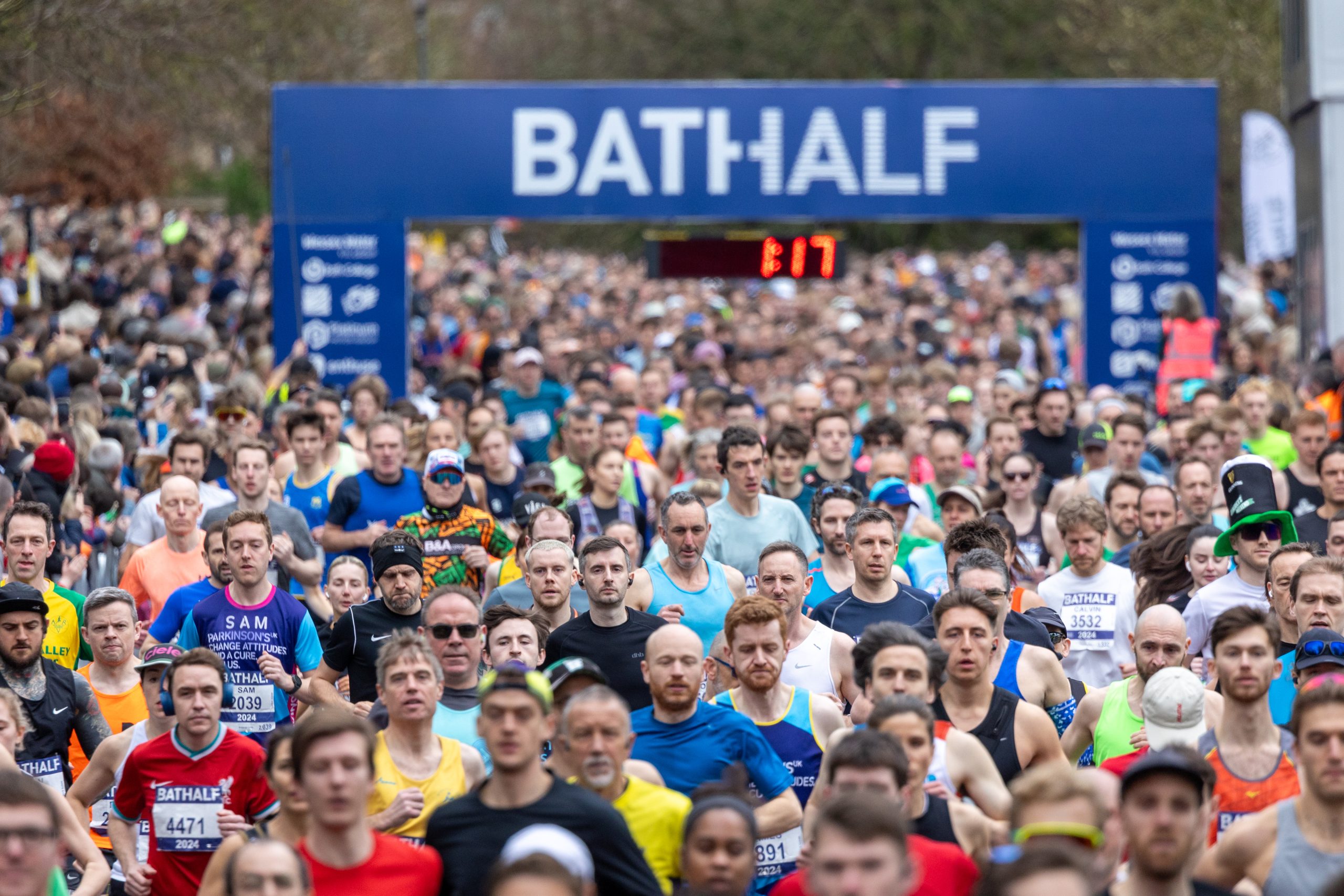 runners at the start line of the Bath Half Marathon with their banner above the runners