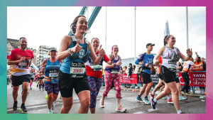 Runners at a marathon in London. Sarah is runnig for Genetic Alliance UK and holds her thumbs up to the camera