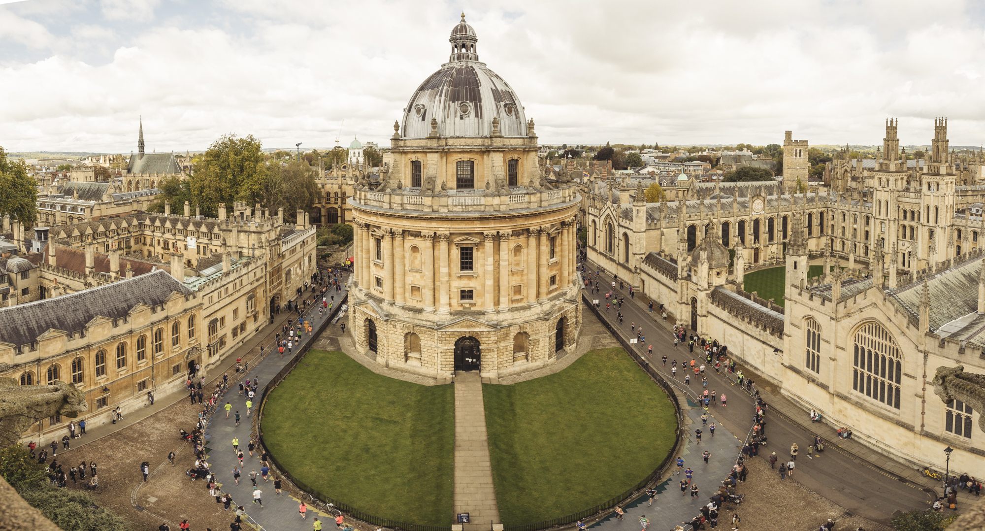 ariel shot of runners at the oxford marathon running around an old beautiful building