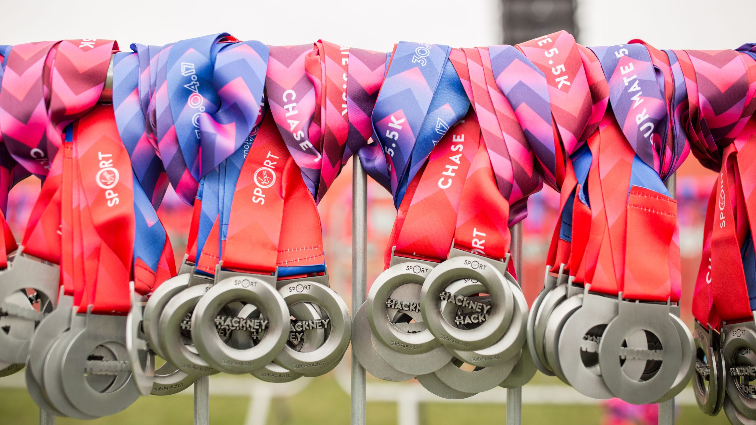 lots of medals for the hackney half hanging on a fence